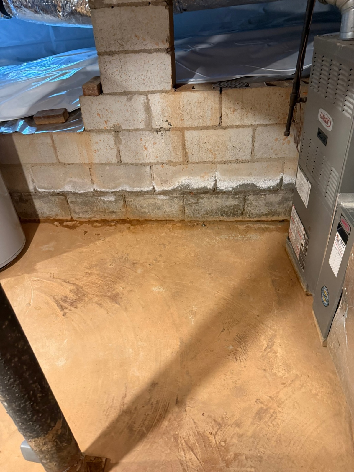 Wet Atlanta basement before waterproofing — water staining at the wall-floor seam