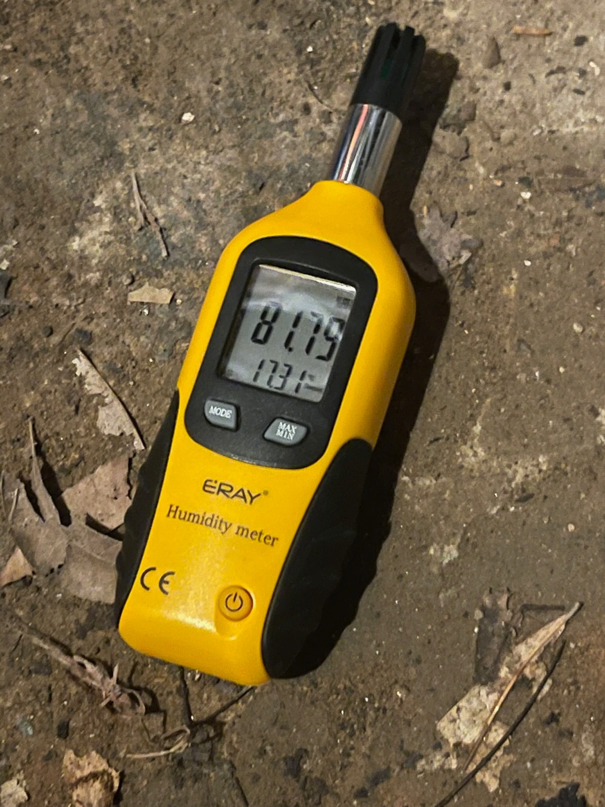 Bare crawl space dirt floor before encapsulation — debris and falling fiberglass insulation