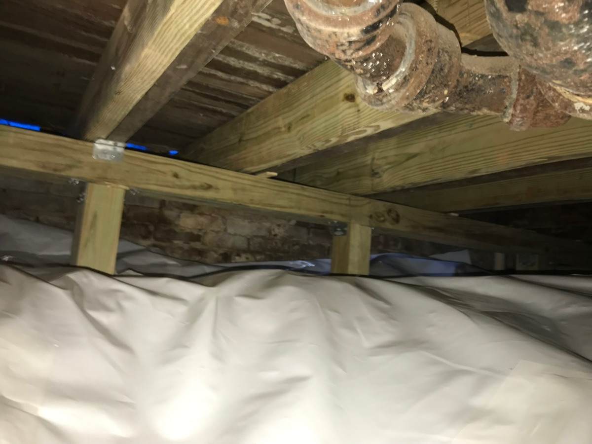 Reinforced floor joists on new structural support after crawl space repair